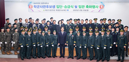 경축 학군사관 후보생 승급 및 입단식이라고 적힌 플랜카드가 보이며 입단한 학생들과 교수님 한군단장님이 중앙에 서 같이 주먹을 불끈 쥔 포즈를 취하고 있다.